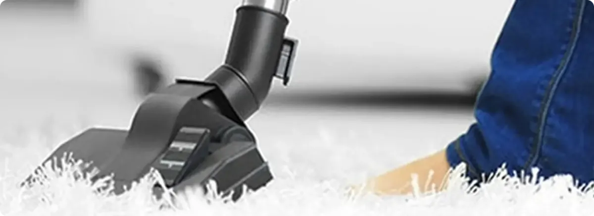 Close-up of a professional vacuuming a white carpet in Lake Forest.